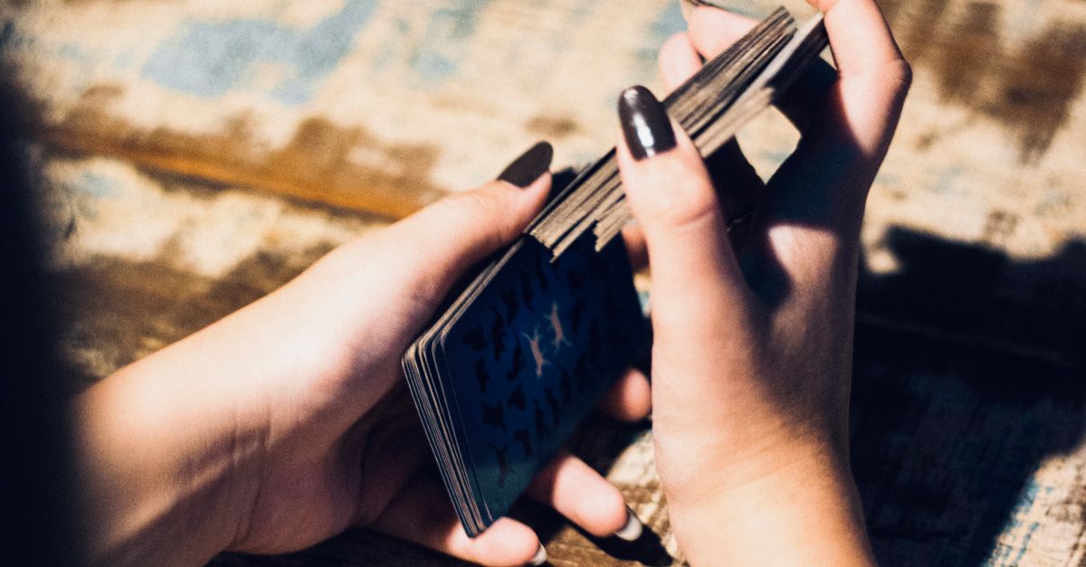 Spielkarten und Hände an einem Kartentisch