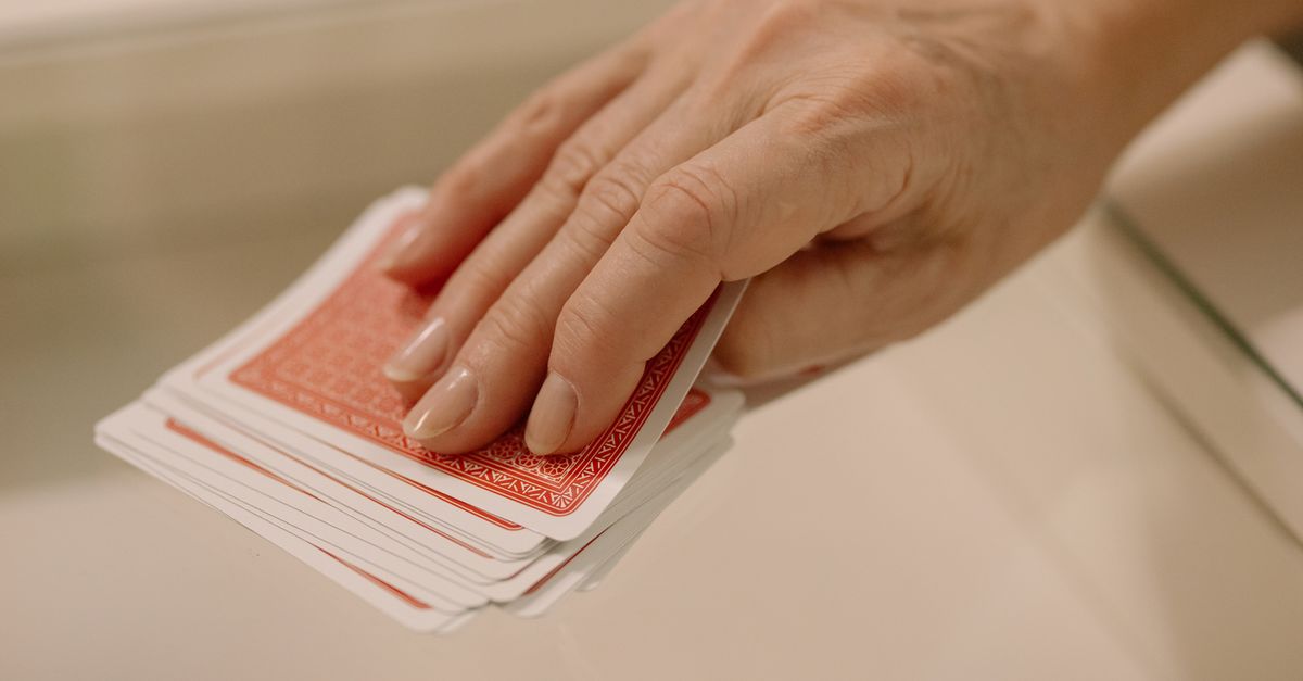 Eine Hand waehlt Karten aus dem Stapel